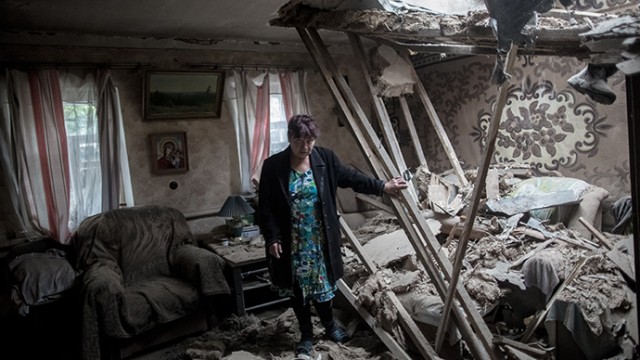 A woman stands in her home destroyed in the Ukrainian troops' shelling of the Golubovka village near Slavyansk on June 27, 2014. (RIA Novosti / Andrey Stenin).